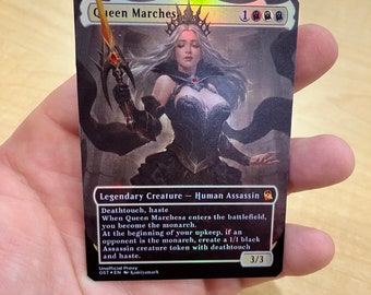 Puede incluir: Una carta de Magic: The Gathering negra y dorada con una mujer con un vestido negro y una corona sosteniendo una espada. El texto de la carta dice "Queen Marchesa" y "Criatura legendaria - Asesina humana". La carta tiene el texto "Toque mortal, prisa" y "Cuando la reina Marchesa entra al campo de batalla, te conviertes en el monarca."