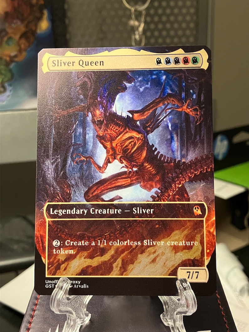 Puede incluir: Una carta de Magic: The Gathering con Sliver Queen, una criatura legendaria con una fuerza y resistencia de 7/7. La carta tiene un fondo negro con una imagen colorida de la criatura. El texto de la carta dice "2: Crea una ficha de criatura Sliver incolora 1/1."