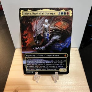 May include: A Magic: The Gathering card featuring Jeleva, Nephalia's Scourge. The card has a detailed illustration of a woman with white hair and a dark creature. The card text includes "Legendary Creature - Vampire Wizard" and other game details.