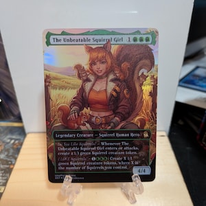May include: A holographic trading card titled The Unbeatable Squirrel Girl, featuring a character with squirrel ears and a large tail, surrounded by squirrels in a field. The card text includes abilities, power and toughness 4/4, and the label Legendary Creature - Squirrel Human Hero.