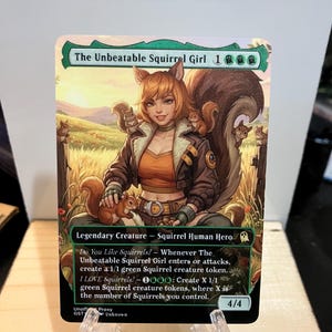 May include: A rectangular trading card titled The Unbeatable Squirrel Girl featuring an illustration of a character with squirrel ears and a large tail surrounded by squirrels in a field. The card text includes abilities, power and toughness 4/4.