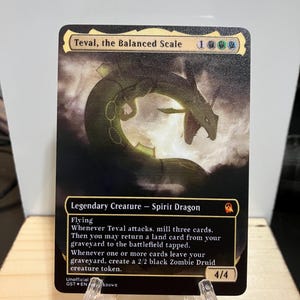 May include: A black and green fantasy creature card with the text "Teval, the Balanced Scale" and "Legendary Creature - Spirit Dragon". The card has a 4/4 power and toughness and has the ability to mill cards and create zombie tokens.