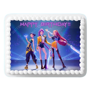 May include: A rectangular cake with a white border and a blue background. The cake features three animated characters and the text "HAPPY BIRTHDAY!!" in pink. The characters are dressed in colorful outfits.