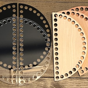 May include: A collection of semi-circular wooden and acrylic basket bases. The bases are in various colors, including clear, black, light wood, and medium wood tones. Each base has evenly spaced holes around the curved edge for weaving.