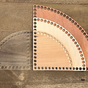 May include: Three circular wooden knitting looms in different sizes. The looms are made of wood and have a natural finish. The largest loom is brown, the middle loom is beige, and the smallest loom is natural wood.
