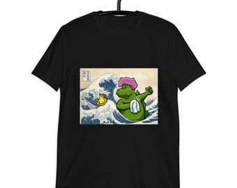 May include: Black t-shirt featuring a graphic of a green alligator wearing a pink shower cap and holding a towel, set against a backdrop of a Japanese wave painting. A yellow rubber duck floats nearby.