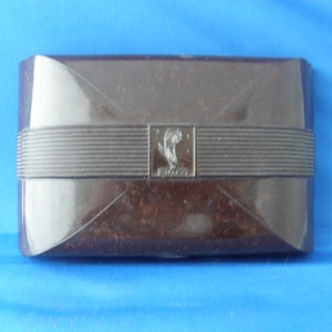 May include: A dark brown rectangular box with a raised, textured design and a silver logo featuring a stylised bird. The logo reads "EDWARDS".