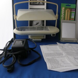 May include: A white computer light with two adjustable arms and a black power adapter. The light is labelled "ECLIPSE Computer Light" and comes with instructions.