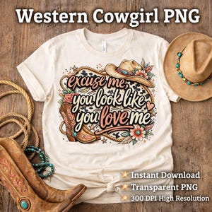 Peut inclure: T-shirt crème avec un motif sur le thème du western. Le motif comprend un chapeau de cowboy, des bottes et la phrase "Excusez-moi, vous semblez m'aimer." Un chapeau de cowboy et des bottes sont également visibles. Le t-shirt est noué à la taille.
