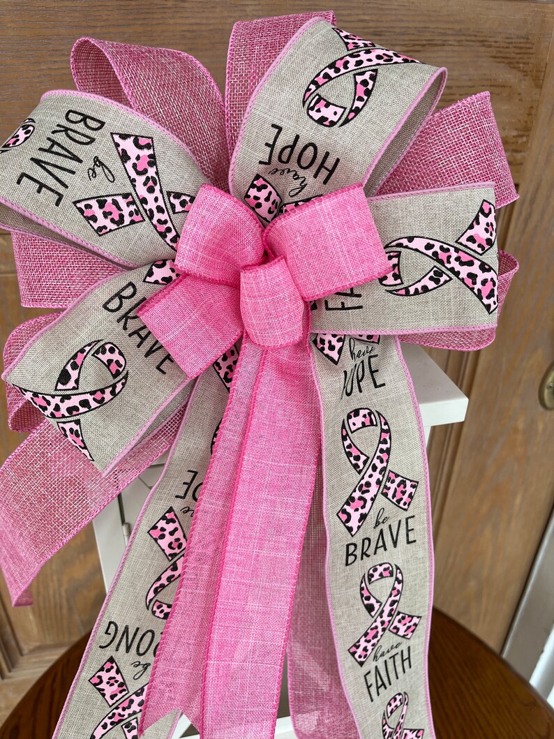 May include: Pink and beige ribbon bow with a pink leopard print and the words "Be Brave", "Have Hope", "Have Faith" and "Be Strong".