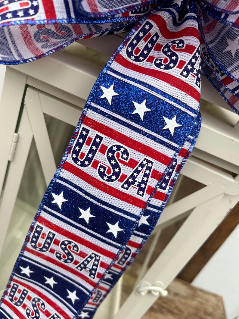 May include: Red, white, and blue ribbon with the word "USA" printed on it. The ribbon is decorated with stars and stripes.