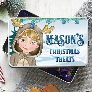 May include: A silver metal tin with a blue and white winter scene. A boy wearing a reindeer costume is on the left side of the tin. The text "MASON'S CHRISTMAS TREATS" is on the right side of the tin.