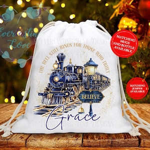 May include: White drawstring bag featuring a blue and gold train illustration with the word "Believe" on a sign. The text "The bell still rings for those who truly" is printed above the train. The name "Grace" is written in cursive below the train.