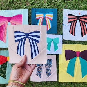 Può includere: Una collezione di modelli di fiocchi di tessuto colorati, ognuno con motivi e combinazioni di colori unici. I fiocchi sono disposti su uno sfondo di erba verde, mostrando una varietà di stili e tonalità.