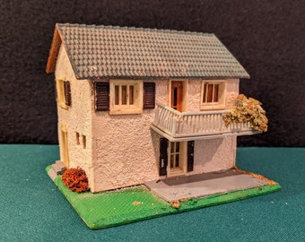 Paisajismo de una casa de dos pisos con tren modelo antiguo