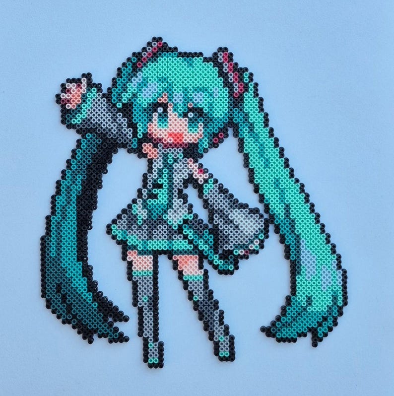 May include: Pixel art of a female anime character with long, turquoise pigtails. The character is wearing a black and gray outfit with pink accents. The artwork is made from small, colorful beads.