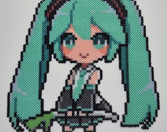 May include: A pixel art depiction of a character with long, turquoise pigtails, large eyes, and a black and gray outfit. The artwork is created using small, colorful beads, giving it a textured appearance. The character is smiling.
