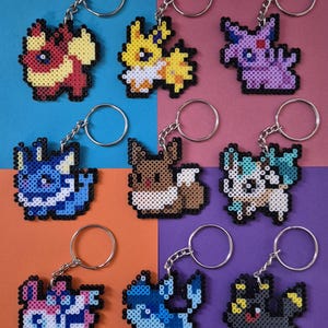 May include: Nine colorful beaded keychains featuring different Pokemon characters. The keychains are made of small plastic beads and are attached to silver key rings.