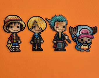 May include: Four pixel art figures from the anime series One Piece, arranged on an orange background. The characters include Luffy, Sanji, Zoro, and Chopper, each rendered in a distinct color palette and style, created with small, colorful beads.