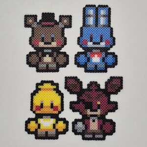 May include: Four pixel art figures of characters from the video game Five Nights at Freddy's. The characters are Freddy, Bonnie, Chica, and Foxy, each in their signature colors. The figures are made of small, colorful beads.