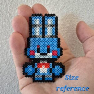 May include: A blue, black, red, and white pixel art character made of small beads. The character has a rabbit-like appearance with large ears and a small bow tie. The text "Size reference" is written in blue below the character.