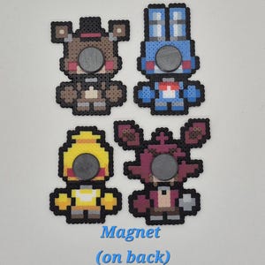May include: Four colorful pixel art magnets featuring characters from a popular video game. The magnets include a brown bear, a blue bunny, a yellow chicken, and a red fox. The text "Magnet (on back)" is visible.