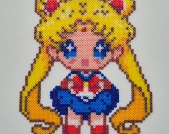 May include: A pixel art depiction of a Sailor Moon character, crafted from colorful beads. The figure features a blue sailor suit, red accents, and long blonde hair. The image includes the text "Miniperlerdutchhess".