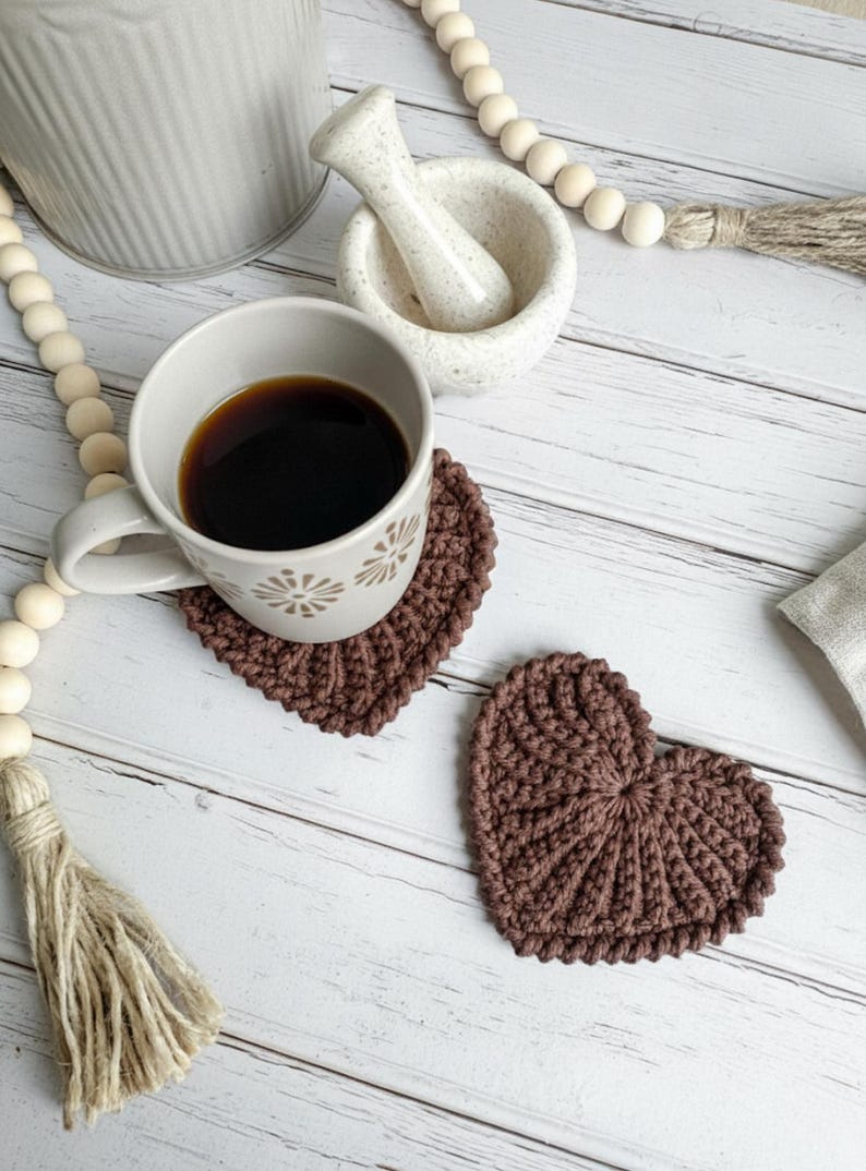 Frejdis heart coasters are beautiful, timeless, and the perfect handmade gift for someone you love. Crochet them in warm gingerbread tones for Christmas – or in soft pink and red for Valentine´s Day. A handmade detail that brings a touch of love to your table all year round! ♡ Tea, coffie, warm chocolate, christmas vibes, christmas gift ideas, gift for her, gift for him
Crochet heart mugrugs. The perfect and quick handmade valentine gift.  Heart, elegant, classic, simple design. Animo design
