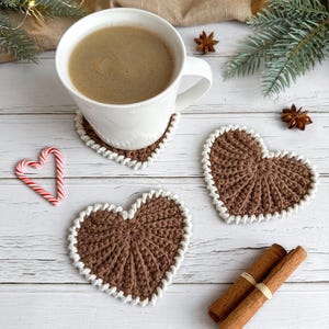 Frejdis heart coasters are beautiful, timeless, and the perfect handmade gift for someone you love. Crochet them in warm gingerbread tones for Christmas – or in soft pink and red for Valentine´s Day. A handmade detail that brings a touch of love to your table all year round! ♡ Tea, coffie, warm chocolate, christmas vibes, christmas gift ideas, gift for her, gift for him
Crochet heart mugrugs. The perfect and quick handmade valentine gift.  Heart, elegant, classic, simple design. Animo design