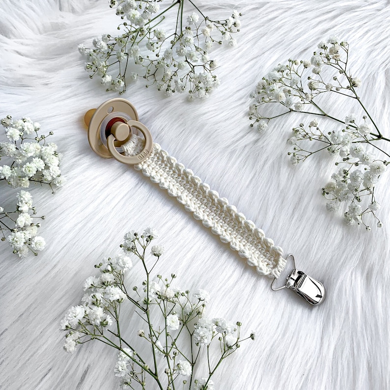 Crochet pacifier clip Vera, pacifier holder, virkad napphållare/nappband, dummy clip, o-ring, binky holder, baby. Perfect handmade gift for new parents. Babyshower gift. Quick easy crochet pattern. Fast crochet project. Romantic, bibs. Animo design