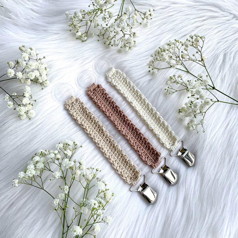 Crochet pacifier clip Vera, pacifier holder, virkad napphållare/nappband, dummy clip, o-ring, binky holder, baby. Perfect handmade gift for new parents. Babyshower gift. Quick easy crochet pattern. Fast crochet project. Romantic, bibs. Animo design