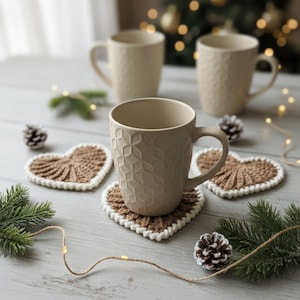 Frejdis heart coasters are beautiful, timeless, and the perfect handmade gift for someone you love. Crochet them in warm gingerbread tones for Christmas – or in soft pink and red for Valentine´s Day. A handmade detail that brings a touch of love to your table all year round! ♡ Tea, coffie, warm chocolate, christmas vibes, christmas gift ideas, gift for her, gift for him
Crochet heart mugrugs. The perfect and quick handmade valentine gift.  Heart, elegant, classic, simple design. Animo design