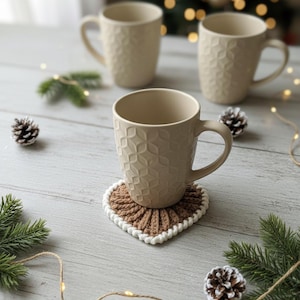 Frejdis heart coasters are beautiful, timeless, and the perfect handmade gift for someone you love. Crochet them in warm gingerbread tones for Christmas – or in soft pink and red for Valentine´s Day. A handmade detail that brings a touch of love to your table all year round! ♡ Tea, coffie, warm chocolate, christmas vibes, christmas gift ideas, gift for her, gift for him
Crochet heart mugrugs. The perfect and quick handmade valentine gift.  Heart, elegant, classic, simple design. Animo design