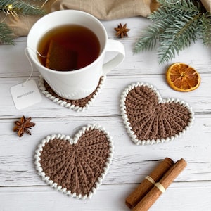 Frejdis heart coasters are beautiful, timeless, and the perfect handmade gift for someone you love. Crochet them in warm gingerbread tones for Christmas – or in soft pink and red for Valentine´s Day. A handmade detail that brings a touch of love to your table all year round! ♡ Tea, coffie, warm chocolate, christmas vibes, christmas gift ideas, gift for her, gift for him
Crochet heart mugrugs. The perfect and quick handmade valentine gift.  Heart, elegant, classic, simple design. Animo design