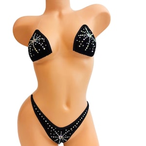May include: Black bikini with rhinestones. The top is a triangle style with clear straps. The bottom is a cheeky style with a small rhinestone detail in the center.