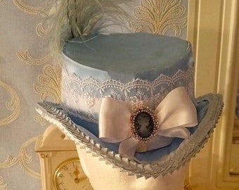Sombrero de copa victoriano/de la época del bullicio en azul cielo con broche de camafeo y plumas de avestruz
