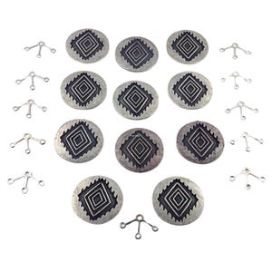 May include: A collection of silver-toned metal jewelry components. The image shows round, textured charms with a geometric design, along with smaller, three-pronged connectors. The components are arranged on a white surface.