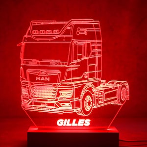 Puede incluir: Una luz de noche LED roja con forma de camión. El contorno del camión está iluminado, con la marca "MAN" visible. El nombre "GILLES" se muestra en la base de la luz.