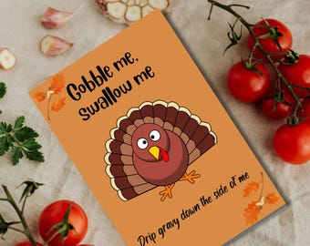 May include: An orange Thanksgiving card with a cartoon turkey illustration. The card features the text "Gobble me. Swallow me" and "Drip gravy down the side of me". Garnishes of tomatoes, garlic, and parsley surround the card.