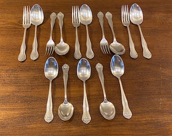 May include: A set of 12 silver-plated flatware pieces, including forks and spoons. The flatware has an ornate design with a floral pattern.