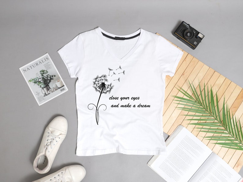 May include: White t-shirt with a black dandelion graphic and the text "Close your eyes and make a dream".