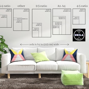 The image is a living room with a white sofa and colorful throw pillows. Above the sofa, there is a wall with a series of black and white photographs depicting different sofa sizes and dimensions. The wall also includes text providing the corresponding measurements for each sofa size.
