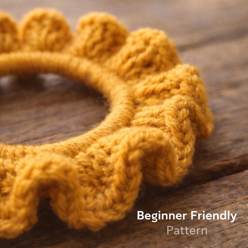 Op de afbeelding: Close-up van een mosterdgeel gehaakte hoofdband met een gerimpelde rand. De tekst "Beginner Friendly Pattern" is zichtbaar in de rechter benedenhoek. De hoofdband is gemaakt van dik, getextureerd garen.