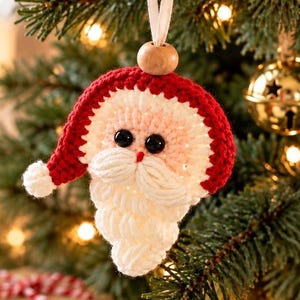 May include: A crocheted Santa Claus ornament featuring a red hat with a white pom-pom, a pale pink face, black plastic eyes, and a thick white yarn beard. A natural wooden bead sits at the top, attached to a white ribbon for hanging on a tree.