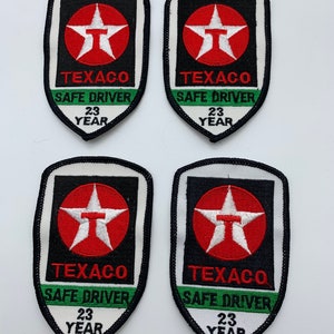 May include: Four black and white embroidered patches with a red star and the text "Texaco Safe Driver 23 Year".