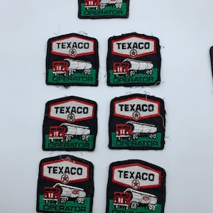 May include: Six black and red embroidered patches with the Texaco logo and the words "Texaco Operator" on a white background.