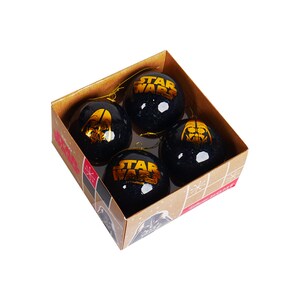 Könnte beinhalten: Set aus vier schwarzen und goldenen Weihnachtskugeln mit Star Wars-Charakteren und -Logos. Die Kugeln befinden sich in einer braunen Schachtel mit einem Schneeflockenmuster.