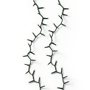 Op de afbeelding: Een string met witte LED-kerstverlichting met groene draad. De lampjes zijn in een willekeurig patroon geregen.