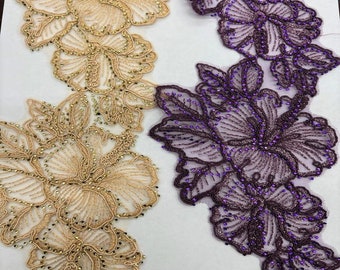 May include: Two floral lace trims. One is a light tan colour with gold-coloured beads. The other is a deep purple with purple beads. Both trims feature a floral design with detailed stitching and beadwork, suitable for embellishments.