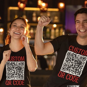 May include: Four people wearing black t-shirts with a custom QR code design and the text "CUSTOM QR CODE" printed in red.